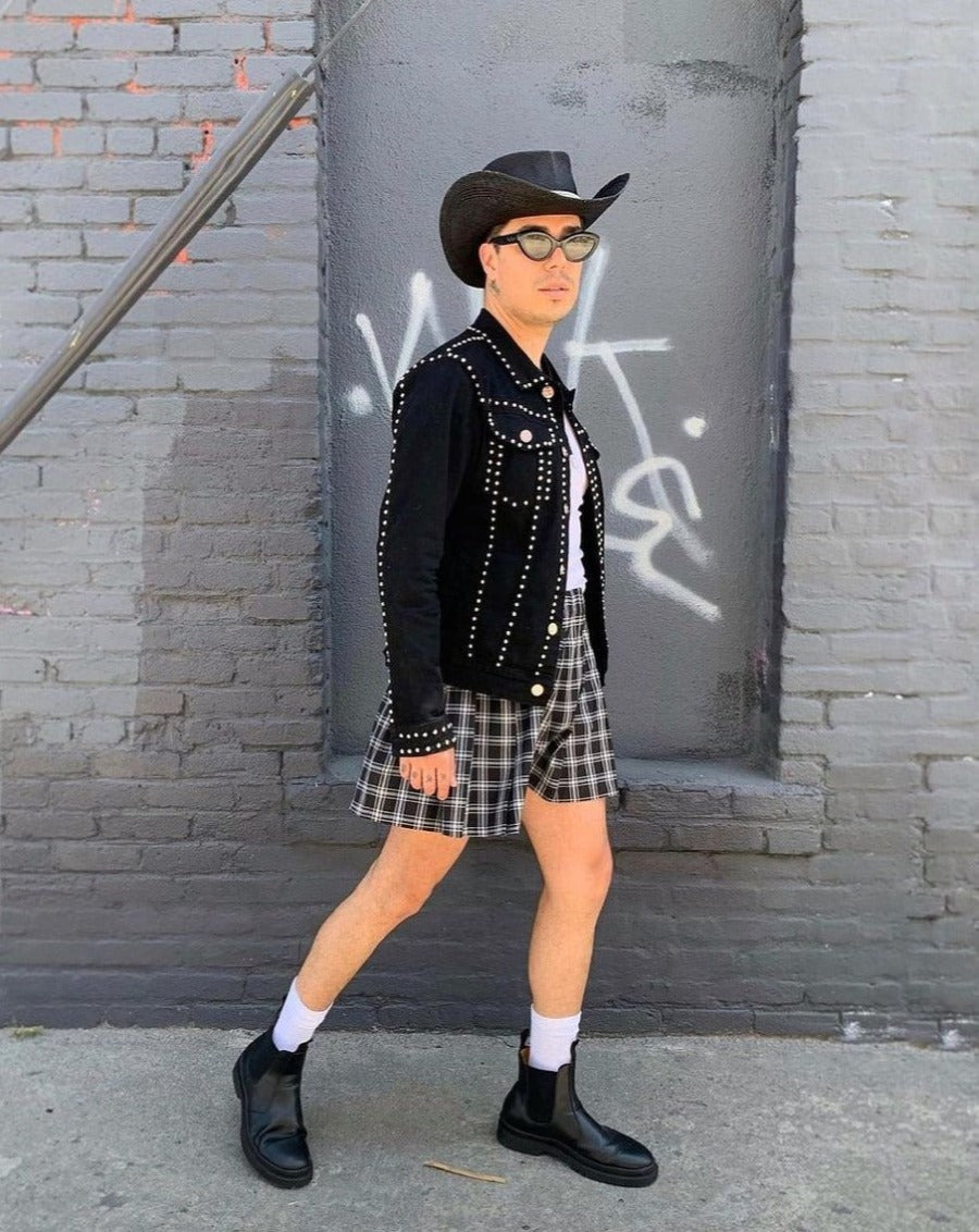 Man posing while wearing a cowboy hat a studded jacket and scribble dot sunglasses Garabato punto 